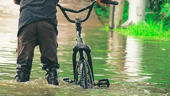 Man with bike in floodwater