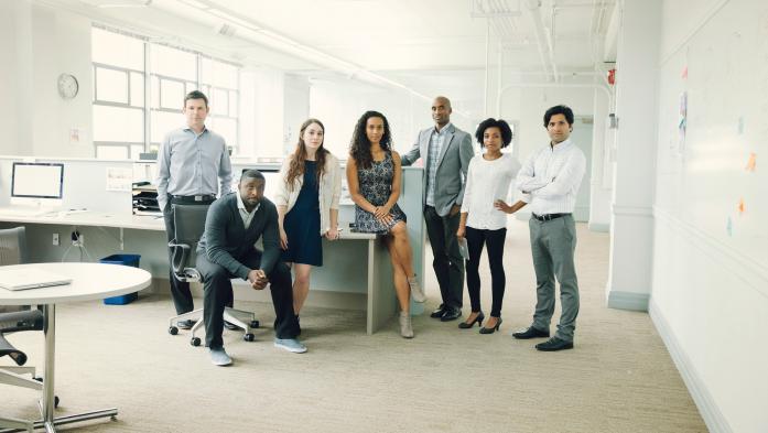 people standing and sitting in an office