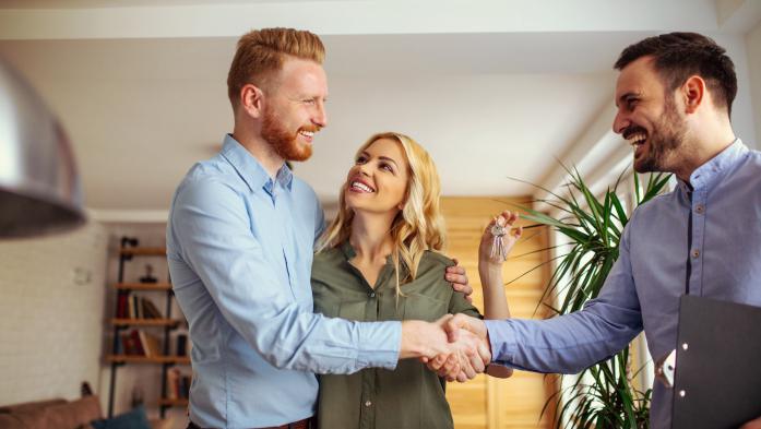 couple shaking hands with a Realtor