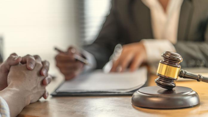 closeup of judge's gavel and closeup and people reviewing paperwork