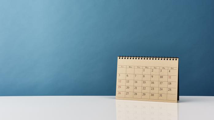 paper calendar standing upright against blue background