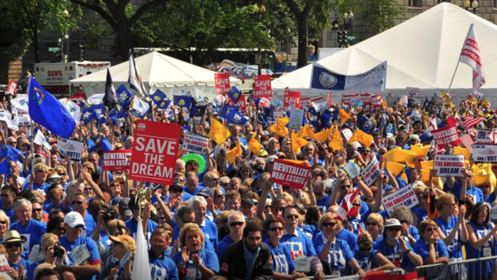 people holding signs and flags at real estate rally in washington