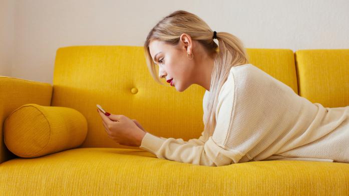 woman on sofa looking at phone