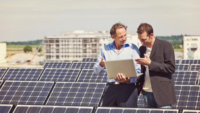 men on building with solar panels