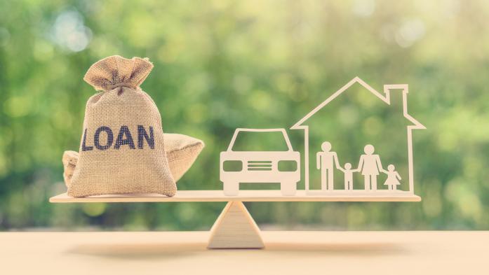 House car and loan money on a balance scale
