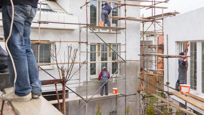 Workers on scaffolding on exterior of a building