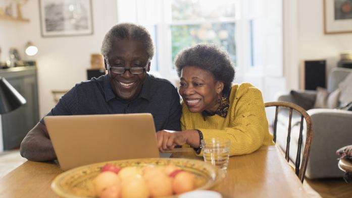 older couple looking at computer and smiling