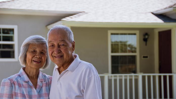 older couple standing outside house