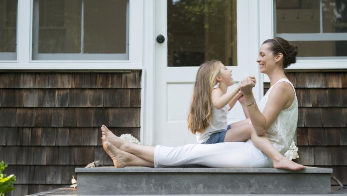 mother and young daughter on porch steps