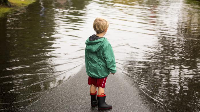 little boy looking at floodwaters