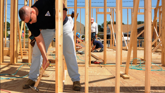 Man pounding nails building an affordable home