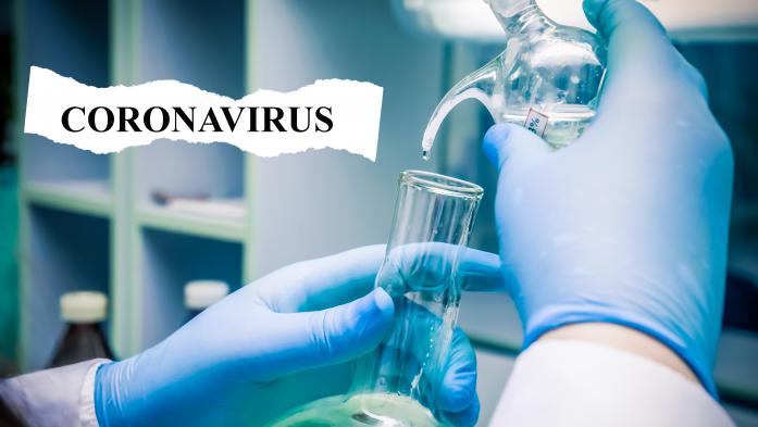 Gloved hands testing liquids for coronavirus