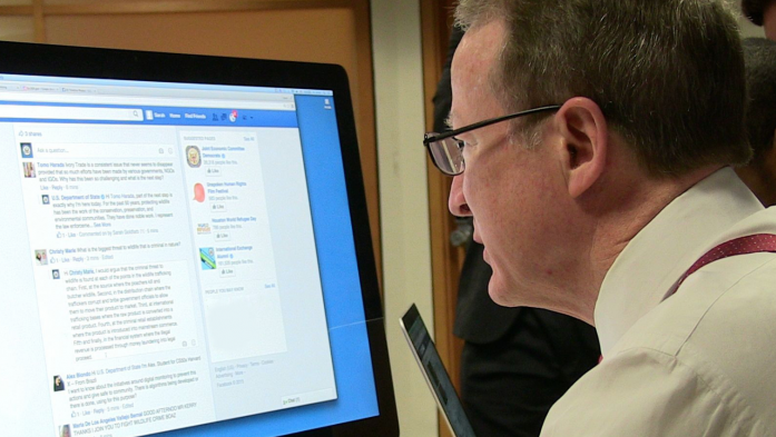 Man at computer looking at Facebook