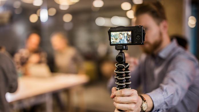 Man holding camera on tripod