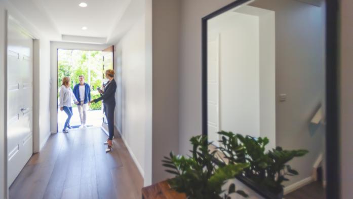 Real estate agent showing a young couple a new house.
