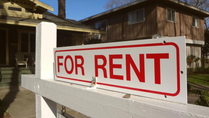 Single-family home with for-rent sign out front