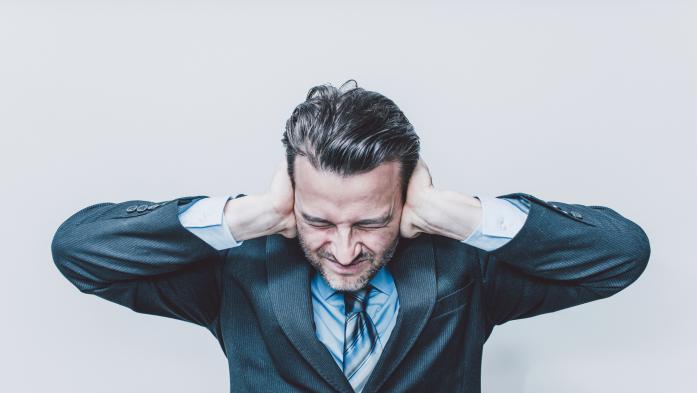 Man holding ears due to noise