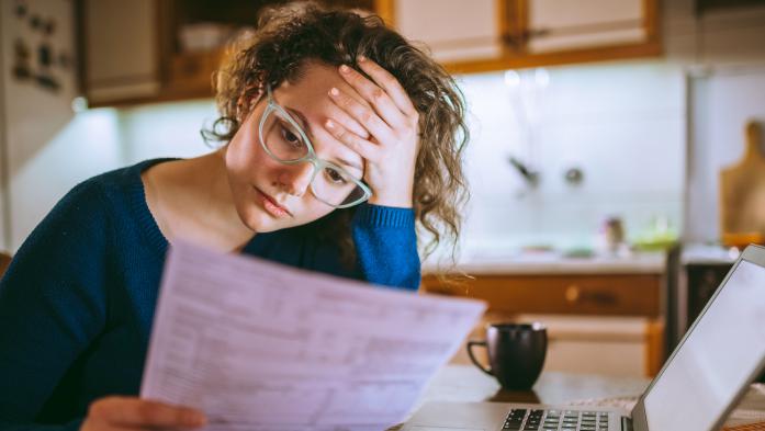 sad woman looking at bills