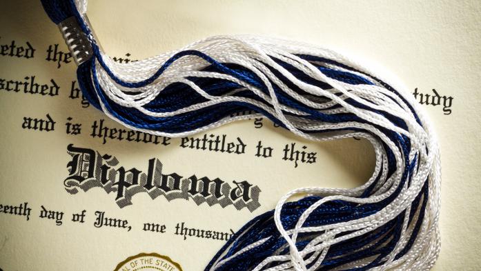 Graduation diploma with tassel across it