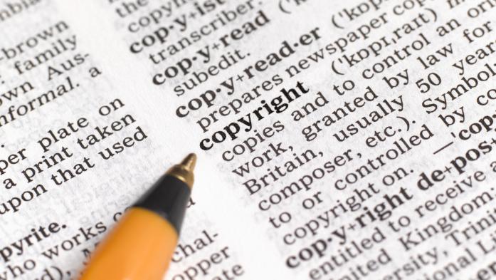 Pen touching the word copyright in a dictionary