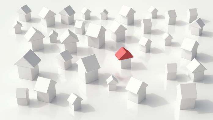 An array of toy block homes and one has a red roof