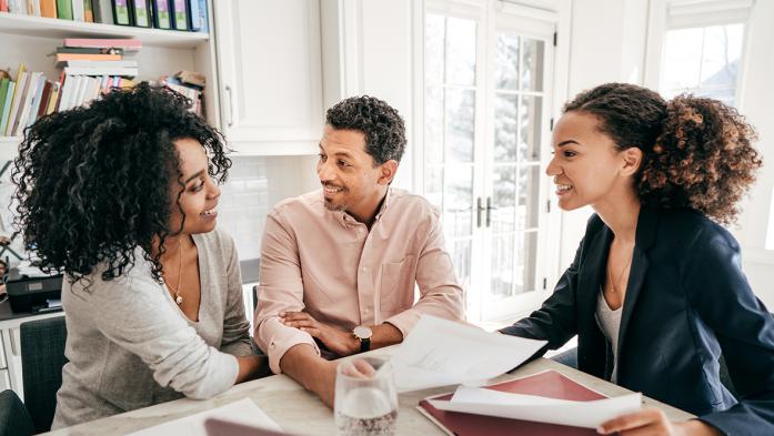 Photo of helpful real estate agent with clients