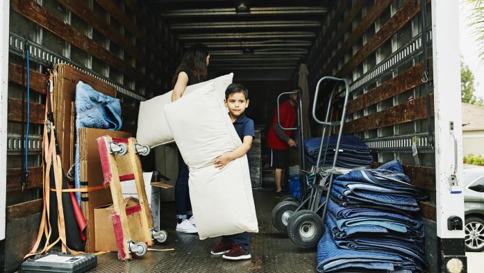 Ten-year old in the back of a moving van helping to unload