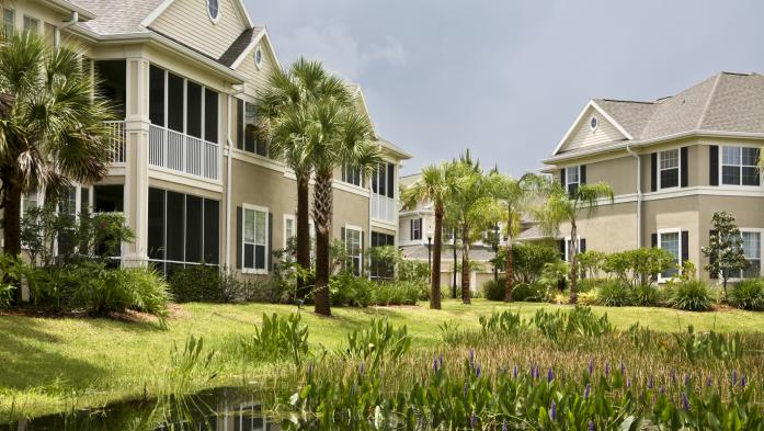 Several condo buildings with screened porches abut a lake