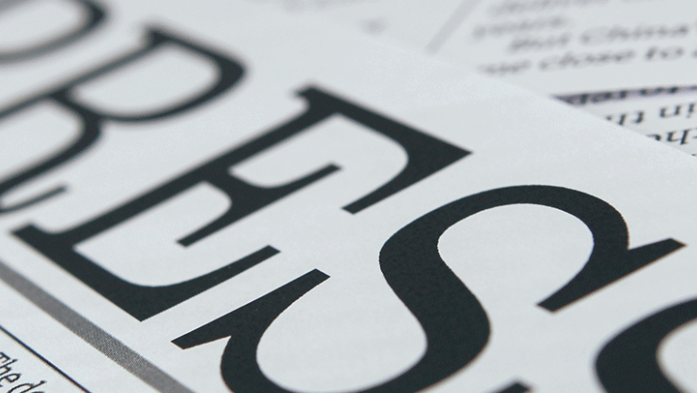Photo of a newspaper with headline reading Press