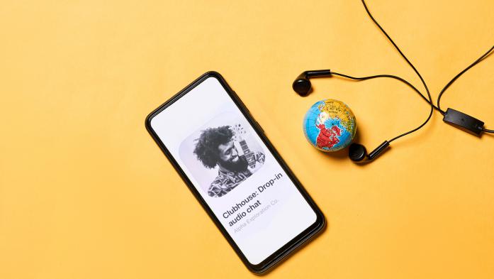 Mobile phone with clubhouse app, small globe and earbuds
