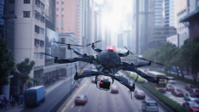 Drone with camera flies over traffic in a city
