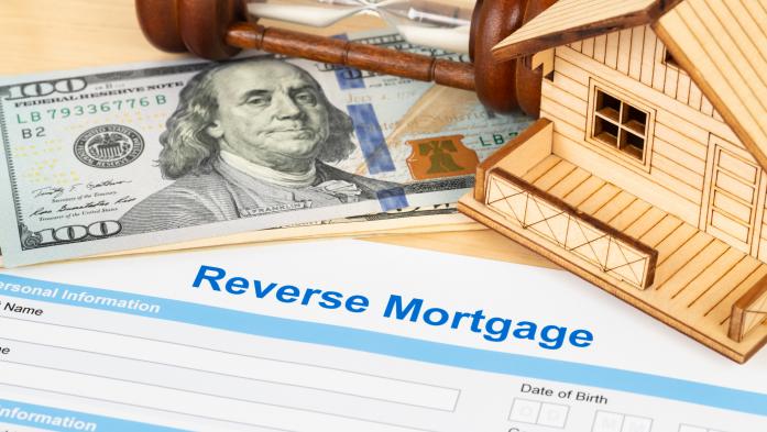 Reverse mortgage application surrounded by money and a toy house