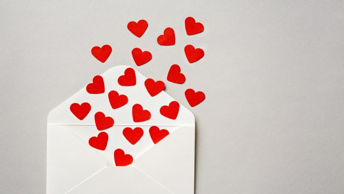 Opened blank envelope with small hearts floating out of it