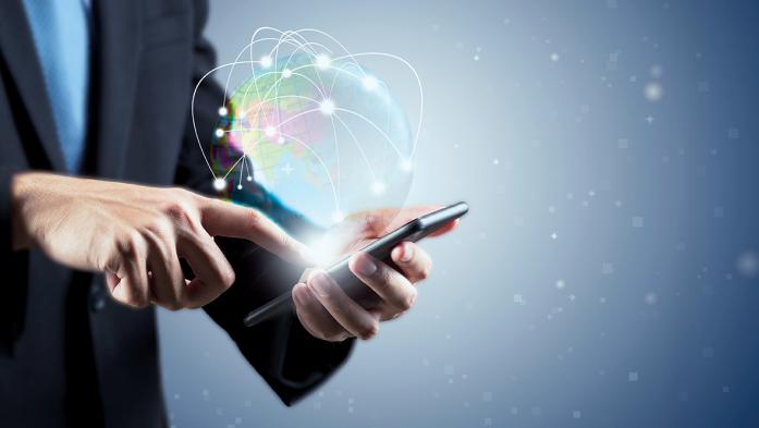 Photo a business man holding a smartphone with a globe glowing above the screen