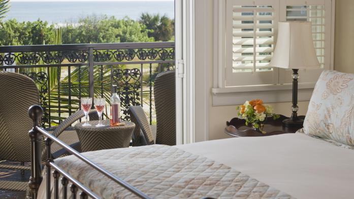 Wrought iron double bed with view through open door to balcony